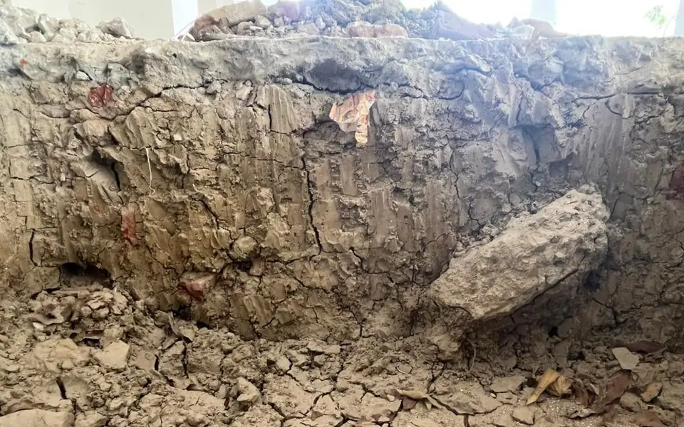 The foundation of a residential block at Gaya before treatment, with cracked, dry soil in the pit dug beside it