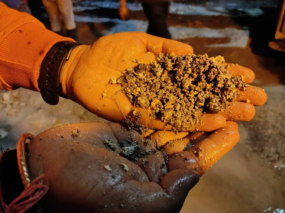 Two gloved hands holding a sample of granular ground on site